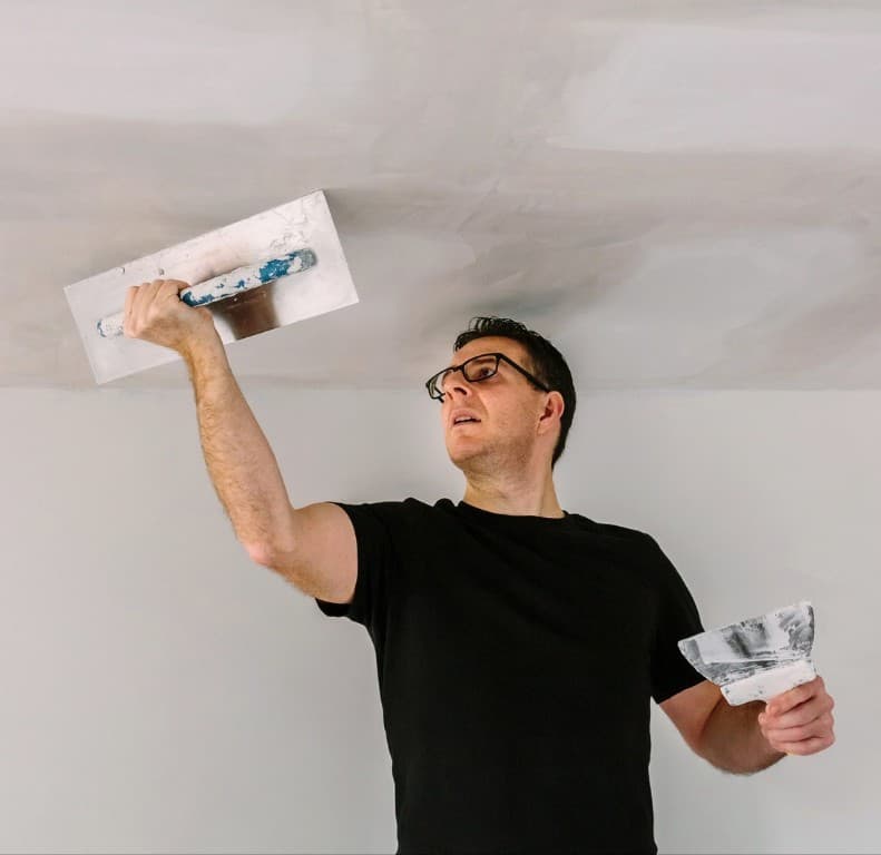 Worker plastering a ceiling